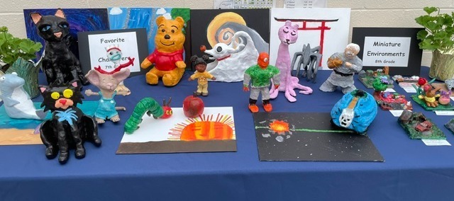 Table of student sculptures and paintings