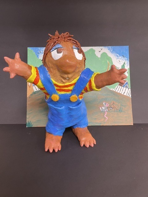 Clay sculpture of a person with open arms 