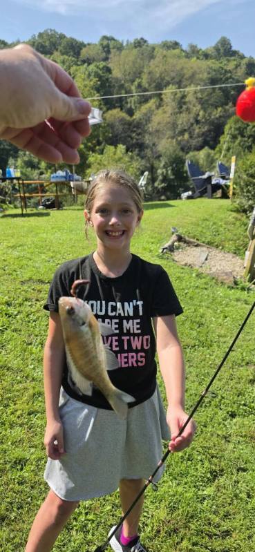 A student in Mrs. Rohrer's classroom shows a fish he caught at Blessed Valley Lodging.
