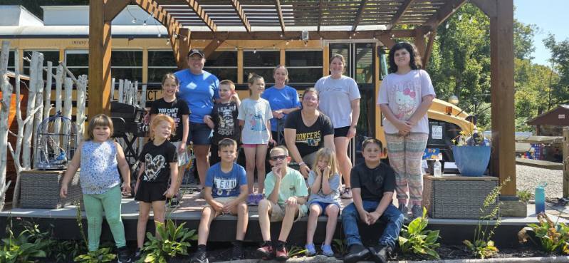 Mrs. Rohrer's class poses in front of the school bus lodge at Blessed Valley Lodging.