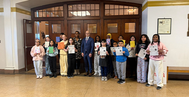 Students standing in hallway holding certificates.