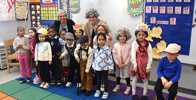 Students smiling with teachers in costume.
