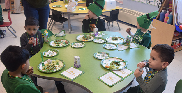 Students eating at green table.