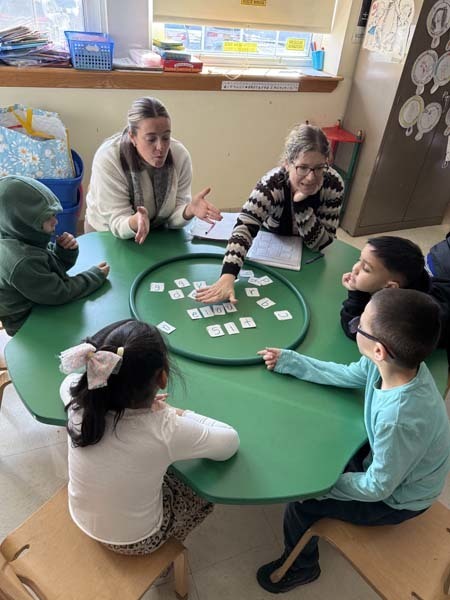 Students playing with cards at table.