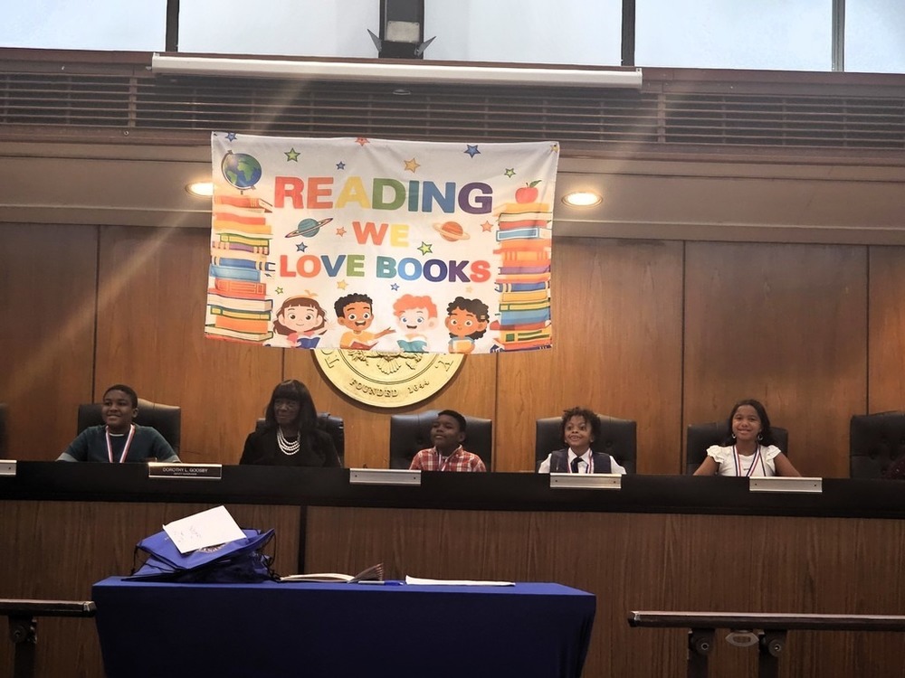 People underneath Banner that Says Reading We love Books