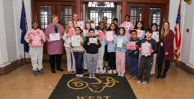 West Hempstead students smiling, holding their art.