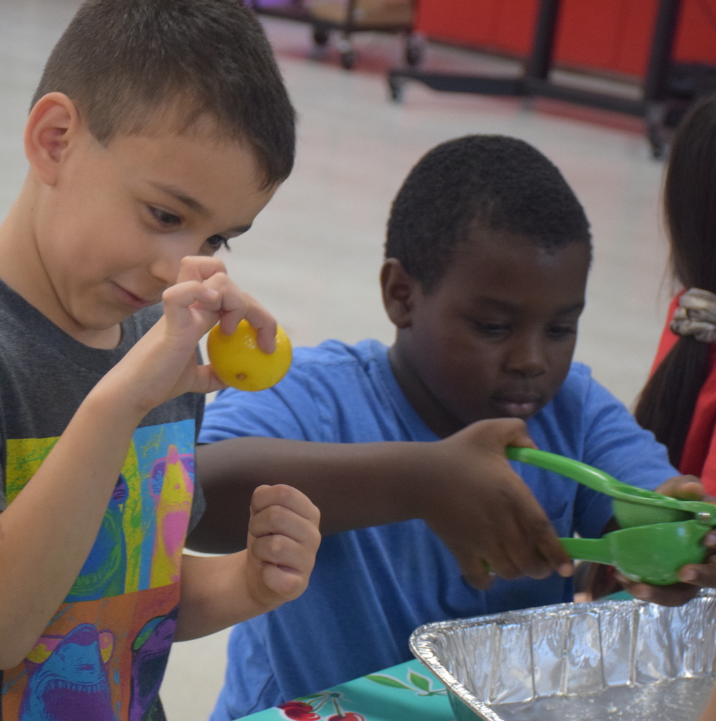 Photo of students squeezing lemonade.