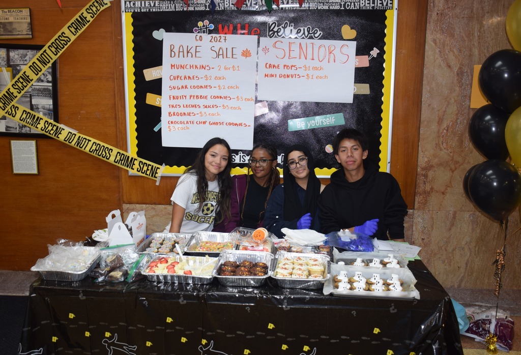 Photo of high school students sitting with baked goods.