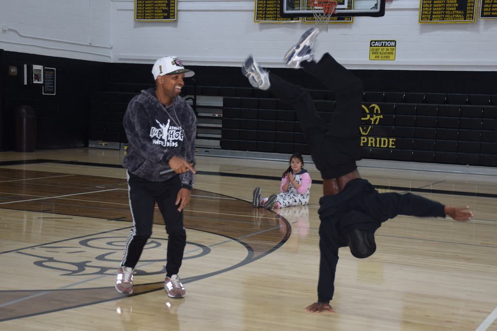 Photo of students dancing in gymnasium with DJ.