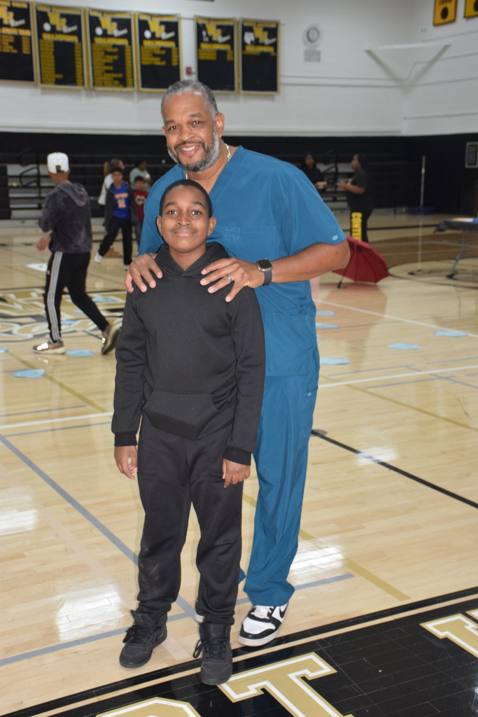 Photo of student with parent in gymnasium.