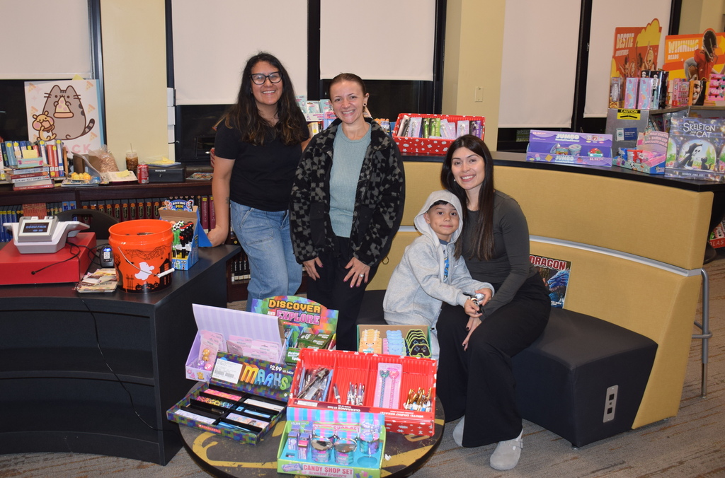 Photo of student, parent with volunteers in library.