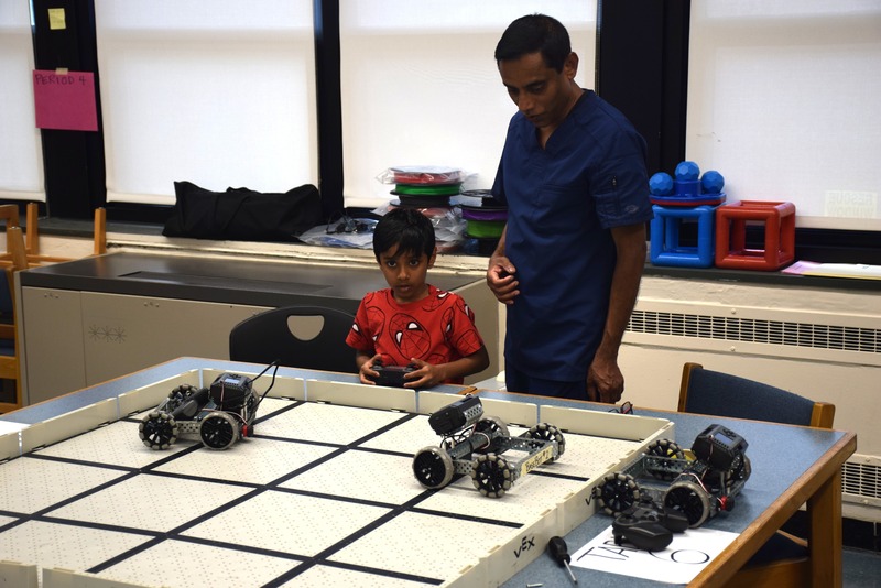 student and parent operating robotic toy vehicle.