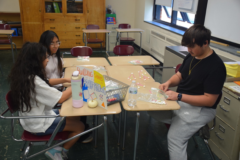Photo of students sitting at desks while building shapes with marshmallows