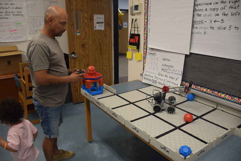 student and parent operating robotic toy vehicle