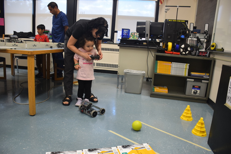 student and parent operating robotic toy vehicle