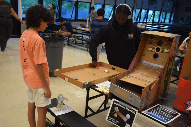 students in cafeteria playing Supernova Skee Ball