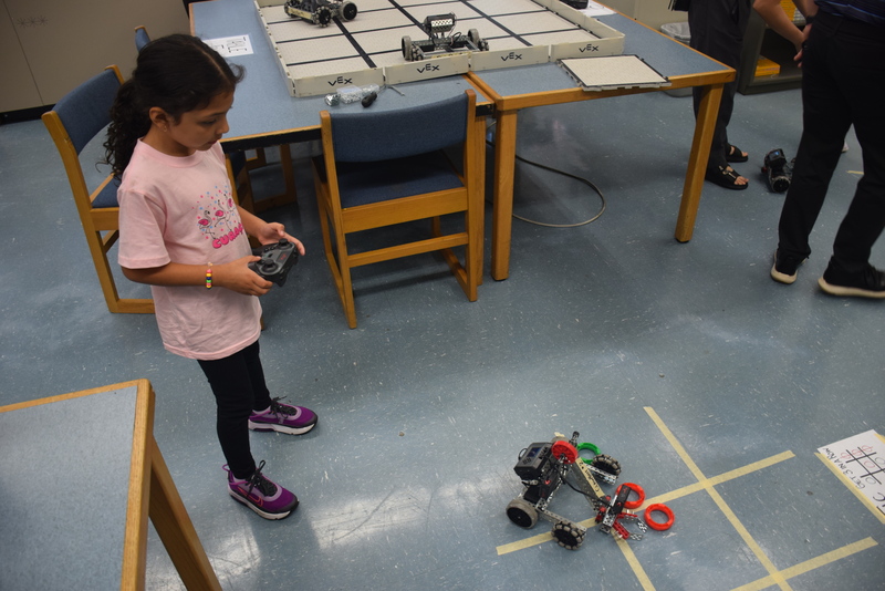 student and parent operating robotic toy vehicle