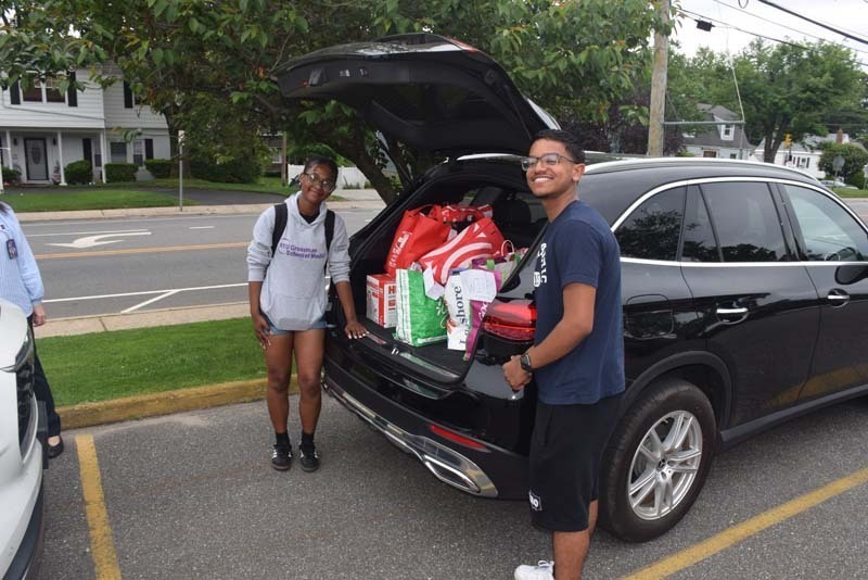 Students outside standing by car with donations.