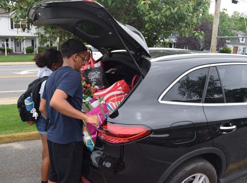 Students outside standing by car with donations.