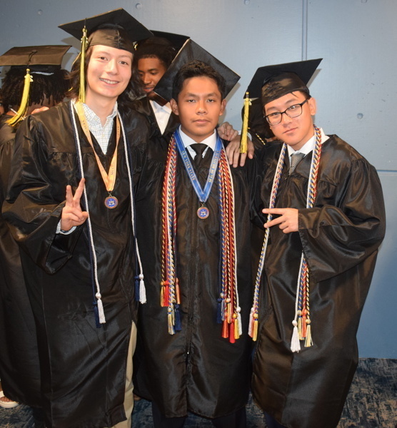 3 graduates in cap and gowns