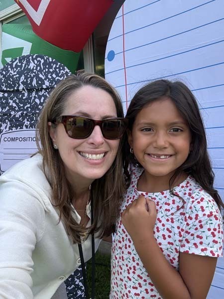 Adult and student smiling together.
