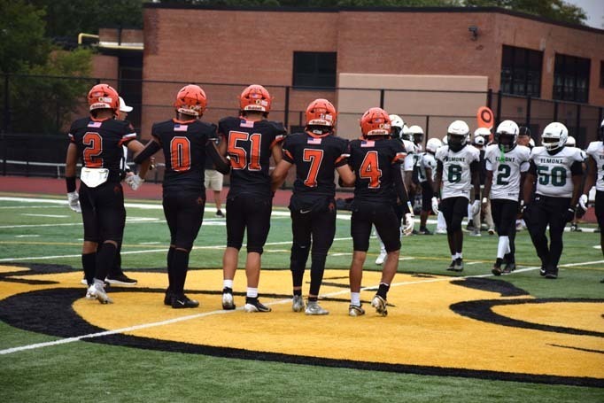 Student football players on field.