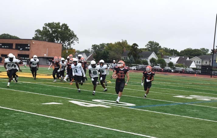 Student football players on field.