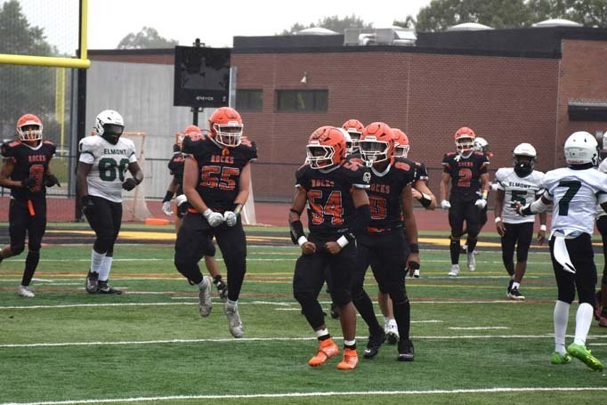 Student football players on field.