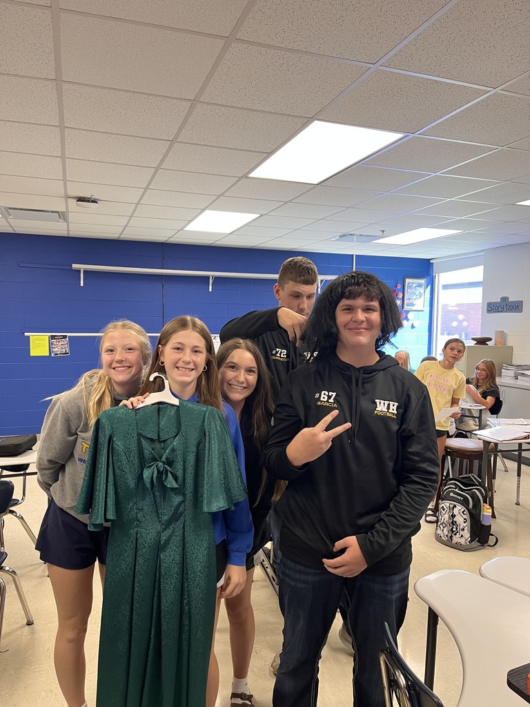 Students giving a haircut to a wig in study hall.