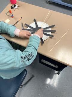 Students made a "walking" spider with construction paper and a wooden skewer.