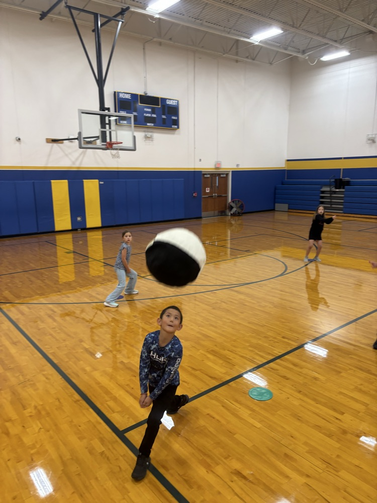 children practicing volleyball in gym