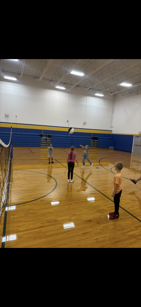 children practicing volleyball in gym