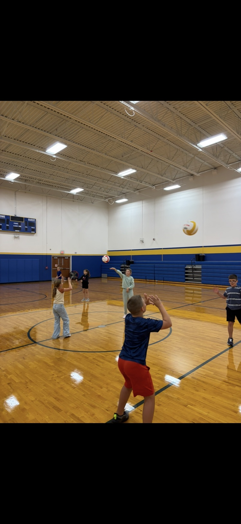 children practicing volleyball in gym