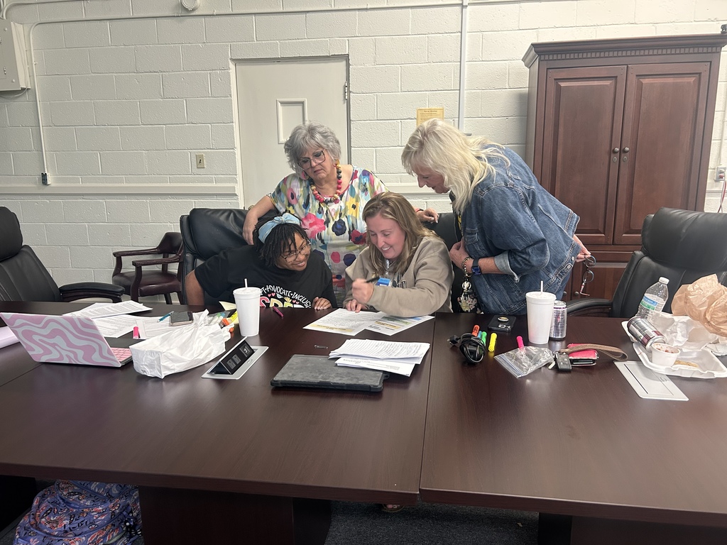 people at a board table working together