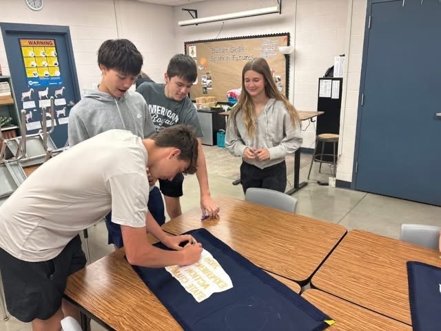 Signing the 2026 Experience the Action State Champion Banner