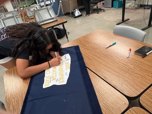 Signing the 2026 Experience the Action State Champion Banner