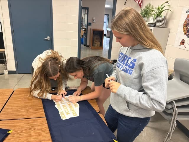 Signing the 2026 Experience the Action State Champion Banner