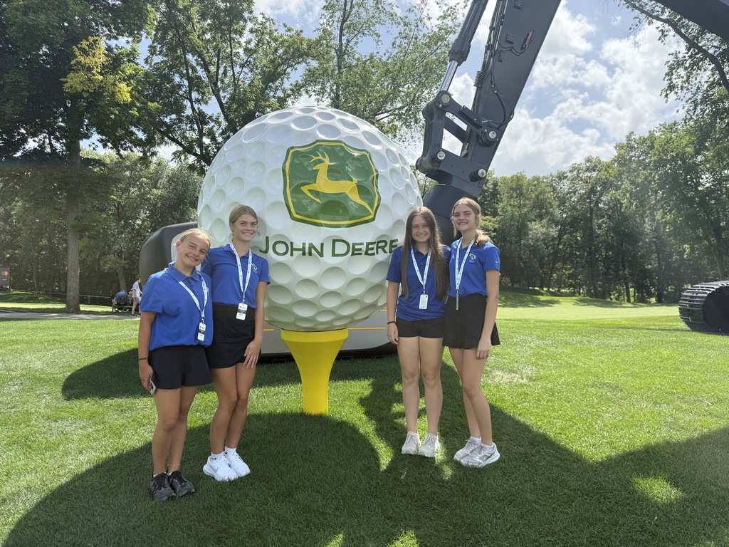 Golfers in front of JDC sign.