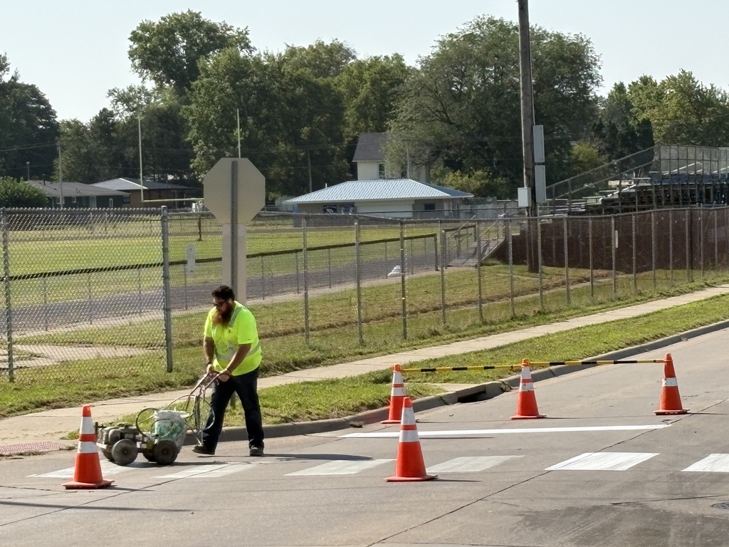 City of West Liberty workers painting crosswalks near WLHS