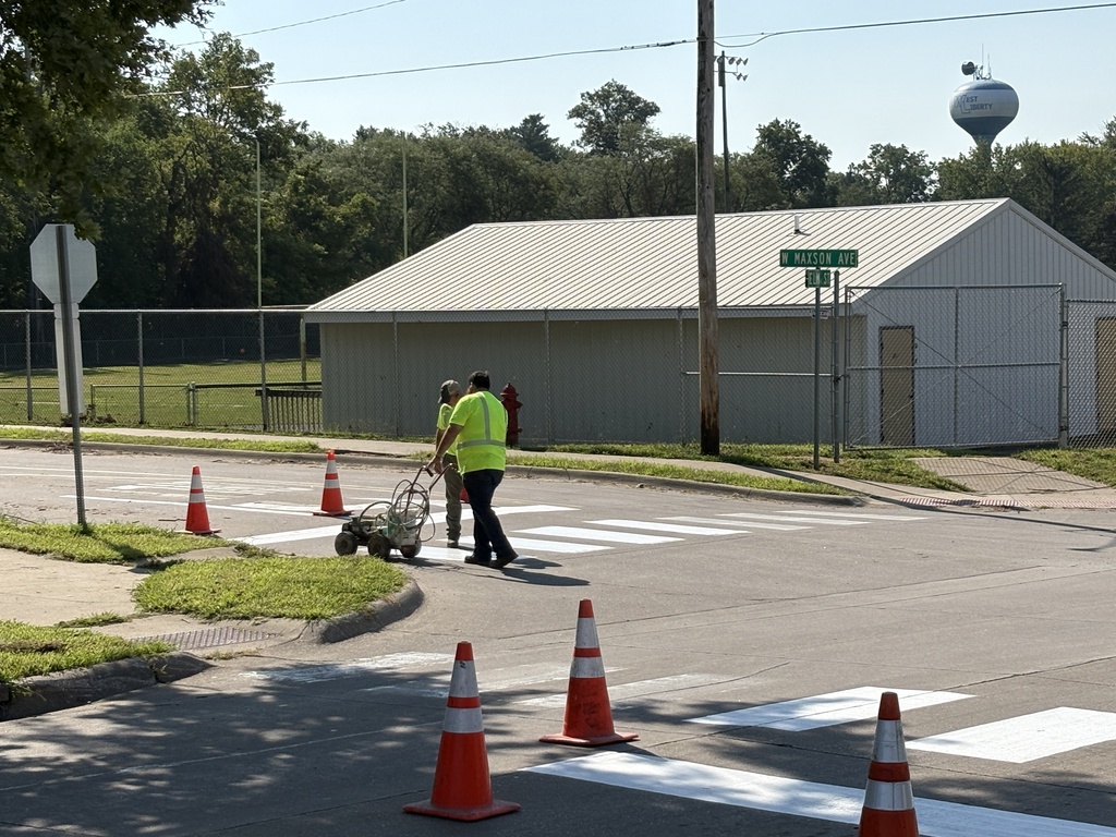 City of West Liberty workers painting crosswalks near WLHS