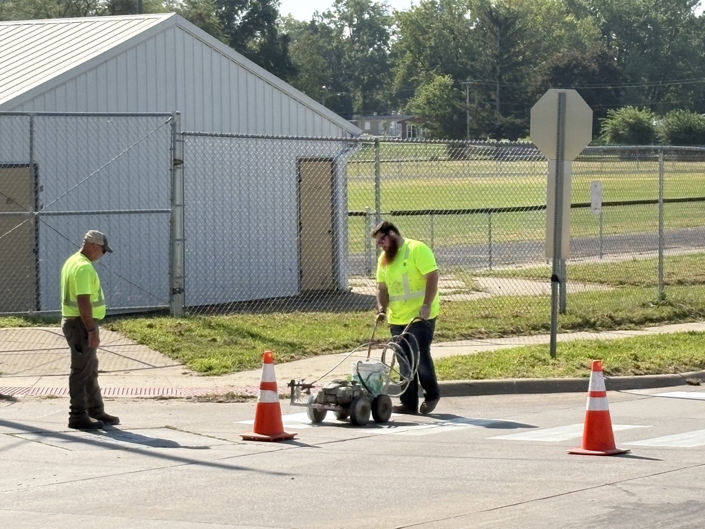 City of West Liberty workers painting crosswalks near WLHS