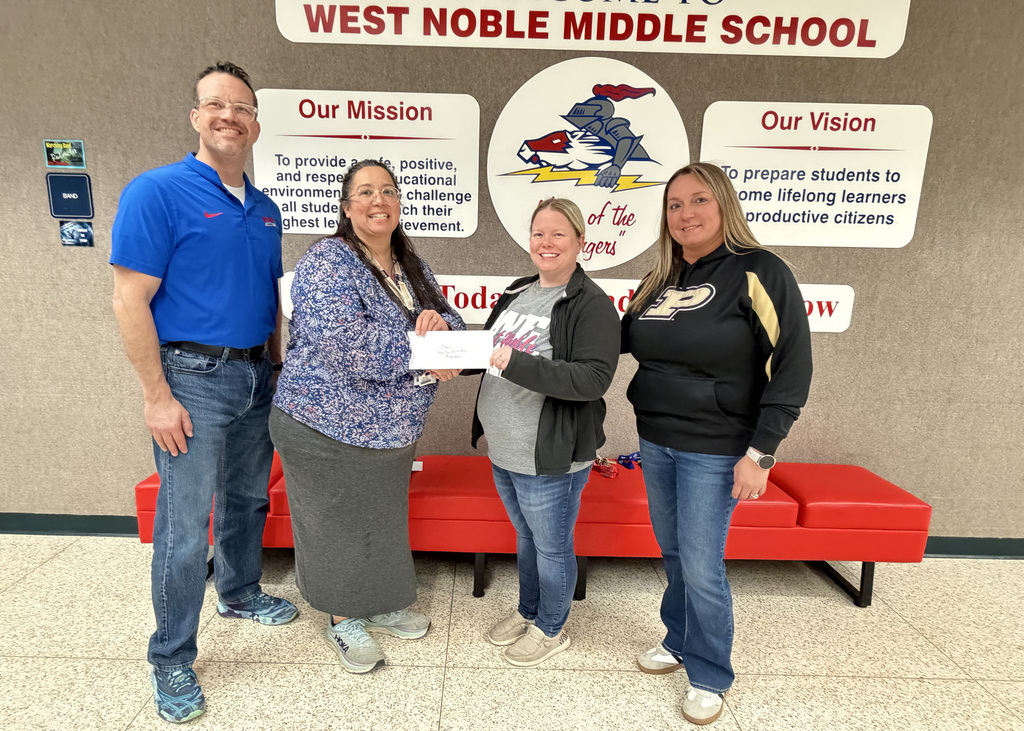 amy church presenting a donation to West Noble choir with three other individuals