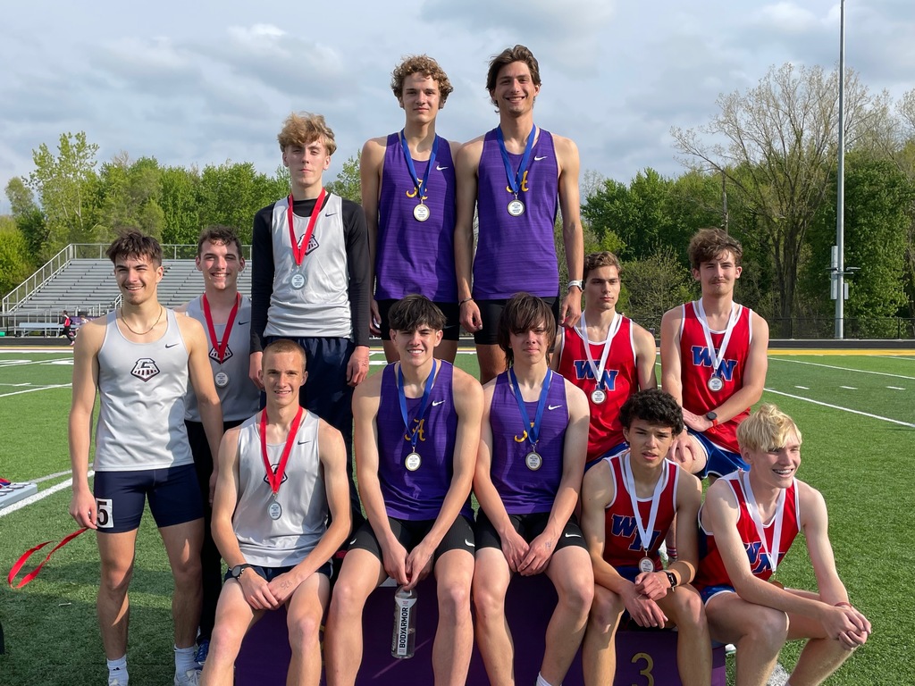 12 boys sitting on a podium at a track meet