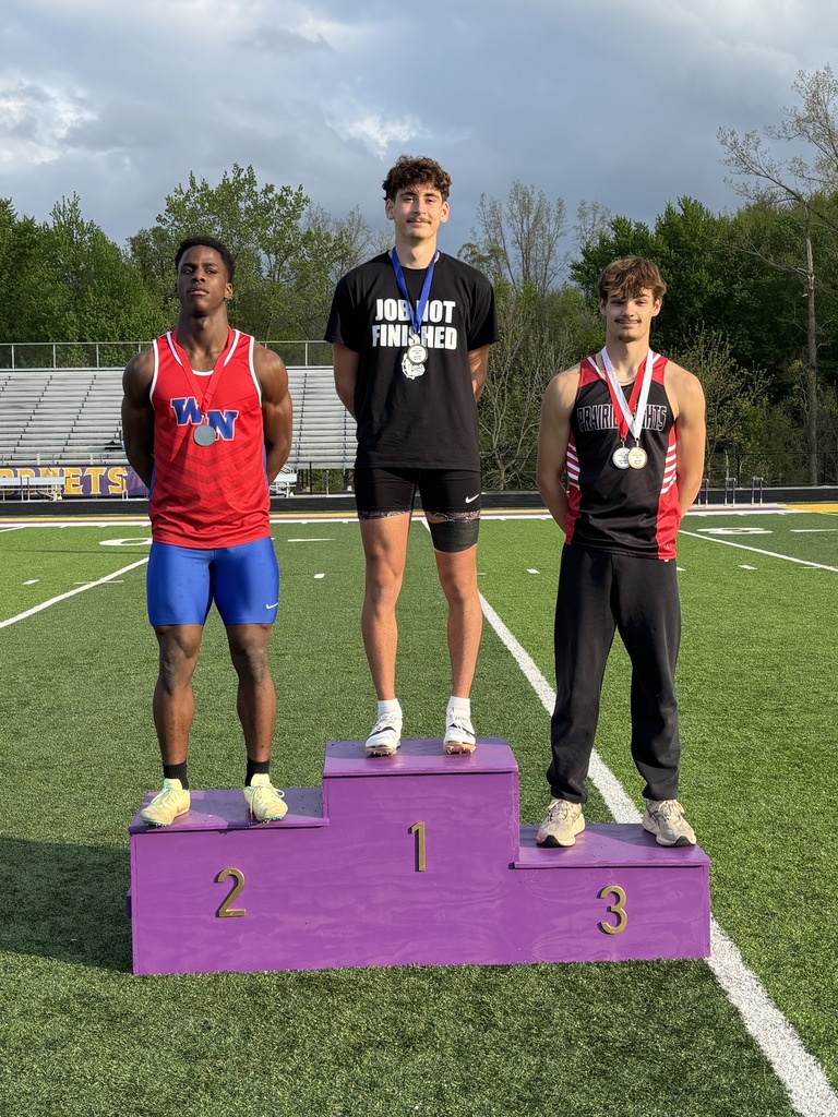 three boys standing on a podium at a track meet