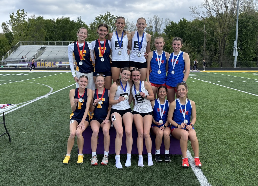 12 girls sitting on a podium at a track meet