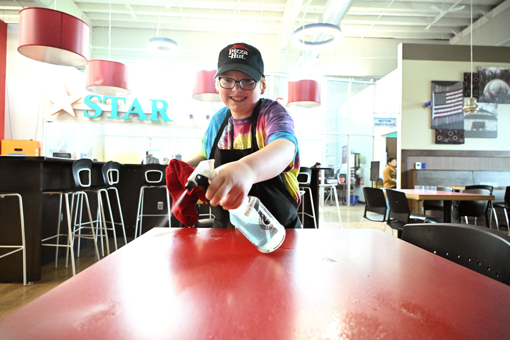 a boy cleaning a table at JA BizTown