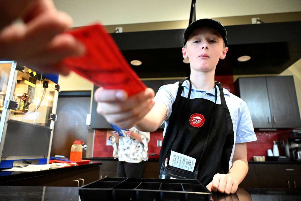 a boy taking a ticket for food at JA BizTown