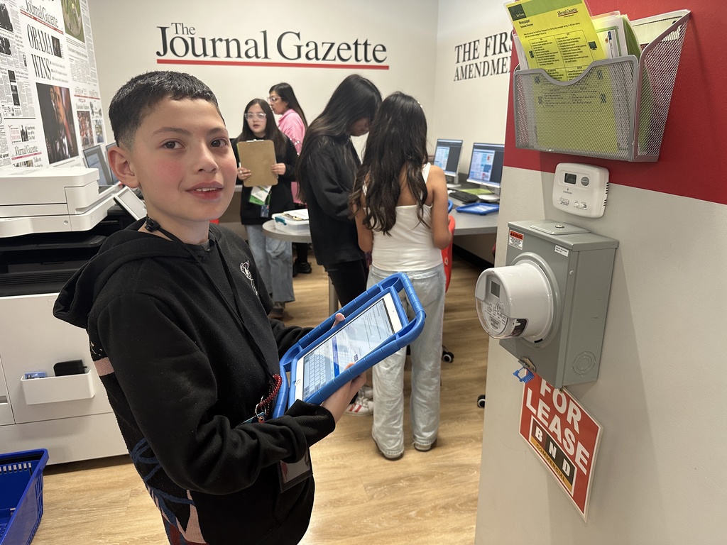 a student holding an ipad and working at JA BizTown