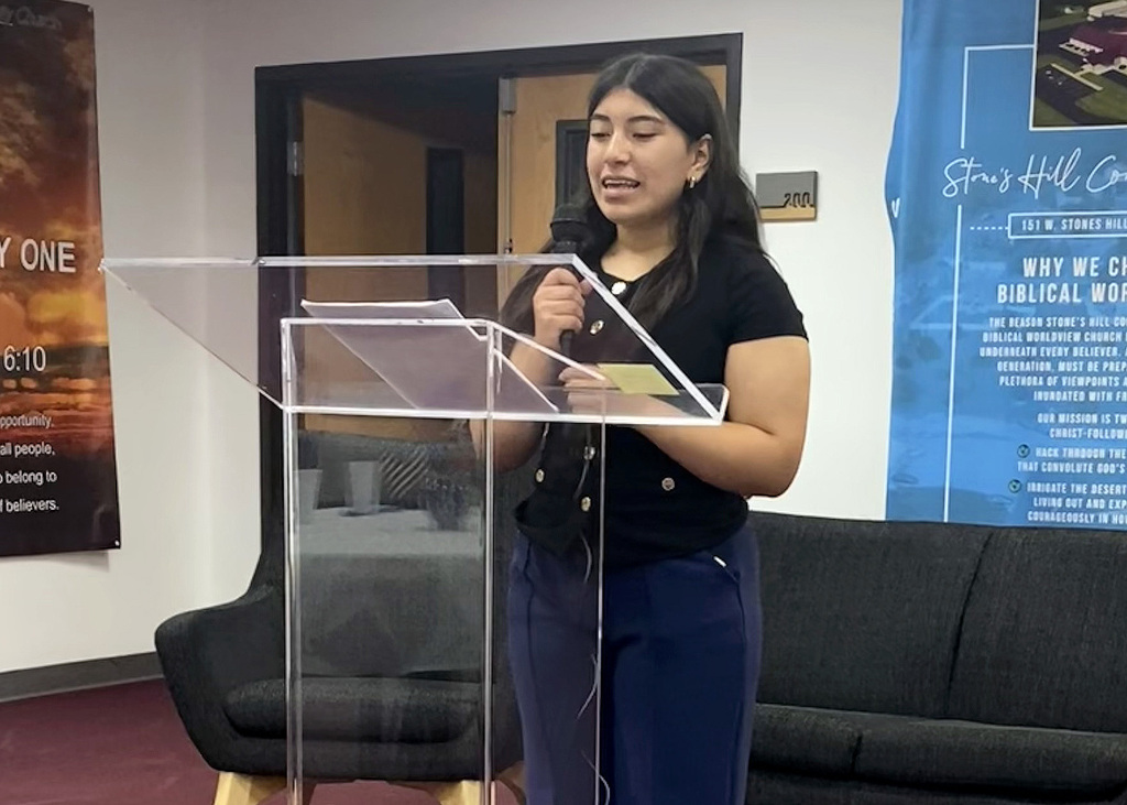 student reading a story at a podium