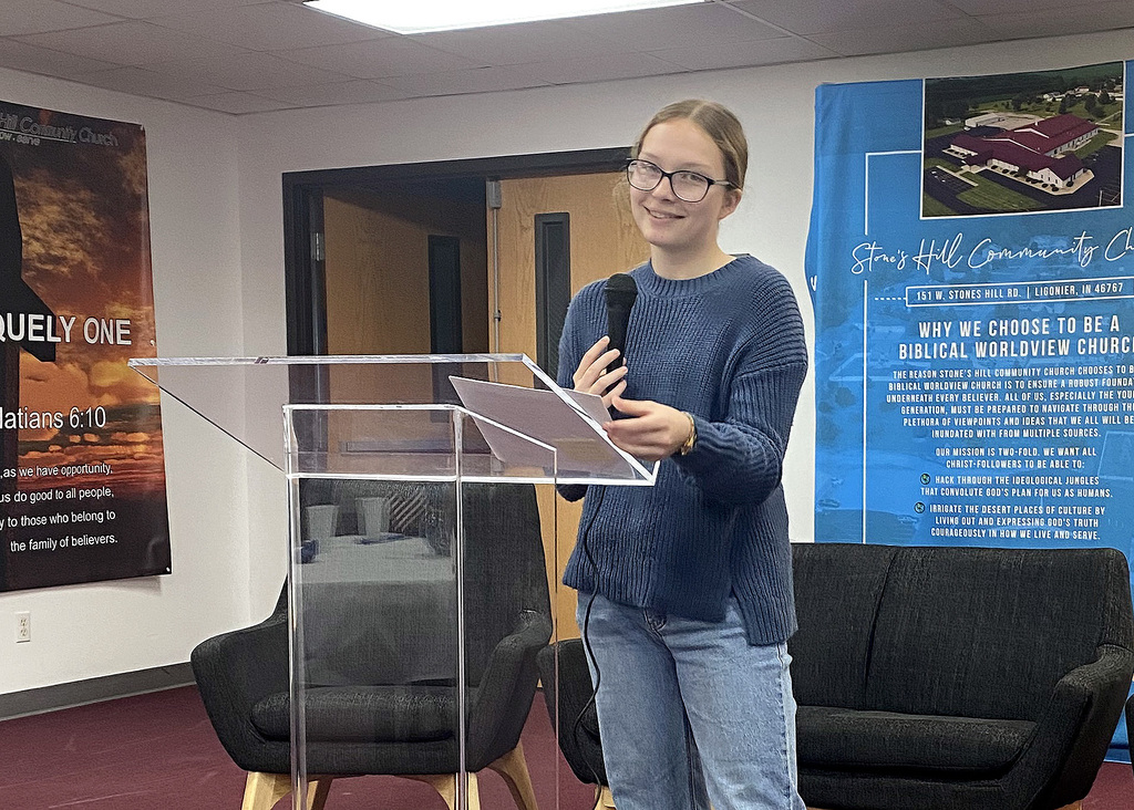 student reading a story at a podium